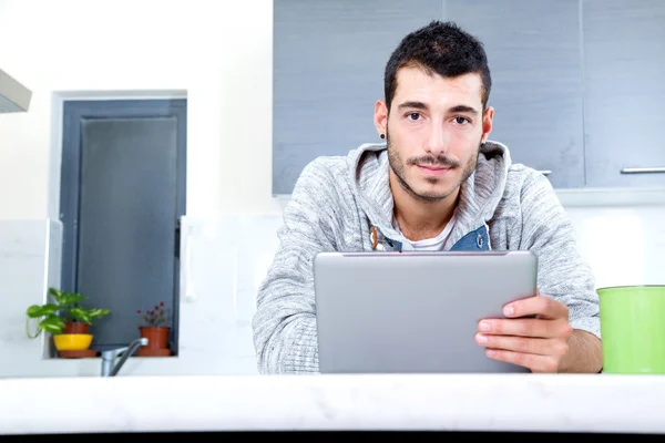 Joven con la tableta en la cocina —  Fotos de Stock