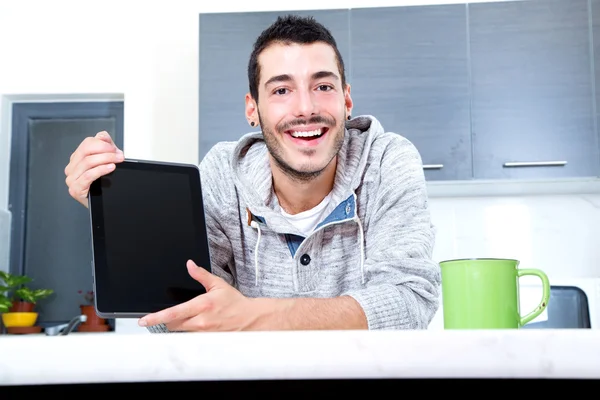 Joven con la tableta en la cocina —  Fotos de Stock