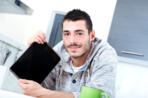 Молодой человек с табличкой на кухне — стоковое фото