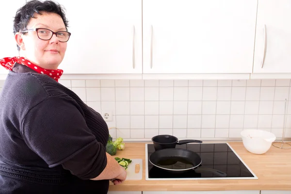 Woman cutting and frying cucumber — Stock Photo, Image