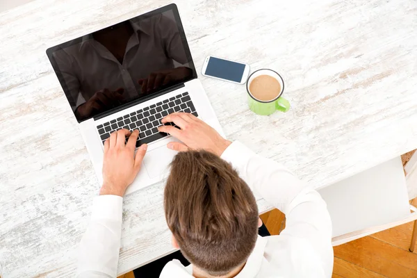 Jeune homme avec un ordinateur portable — Photo