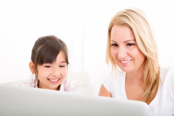 Madre e hija con un ordenador portátil en casa —  Fotos de Stock
