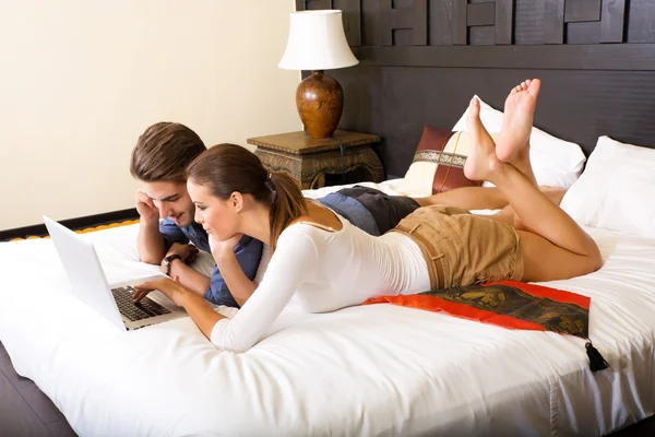 Genç çift bir Asya otel odasında bir dizüstü bilgisayar kullanarak — Stok fotoğraf
