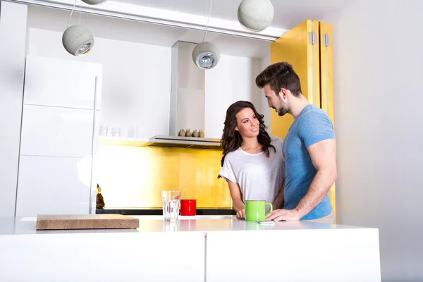 Casal jovem usando um Tablet PC na cozinha em casa — Fotografia de Stock