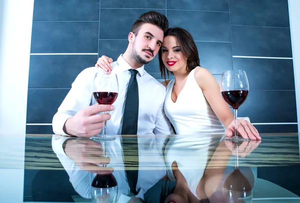 Um casal romântico com um copo de vinho na sala de jantar — Fotografia de Stock