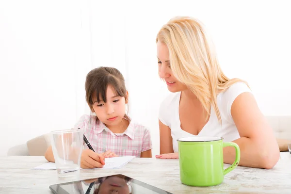 Mamma att hjälpa dottern med läxor — Stockfoto