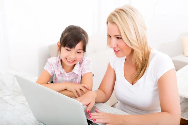 Mère et fille avec un ordinateur portable à la maison — Photo