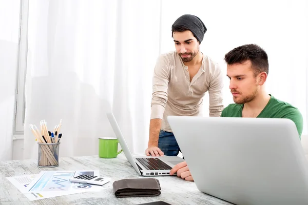 To medarbeidere diskuterer noe på kontoret. – stockfoto