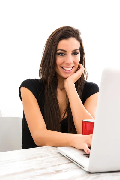 Ung vacker kvinna med en bärbar dator hemma — Stockfoto