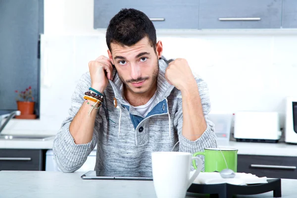 Jovem com tablet na cozinha — Fotografia de Stock