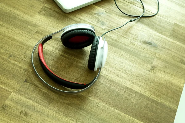 Dispositivos digitais e fones de ouvido em um desktop de madeira — Fotografia de Stock