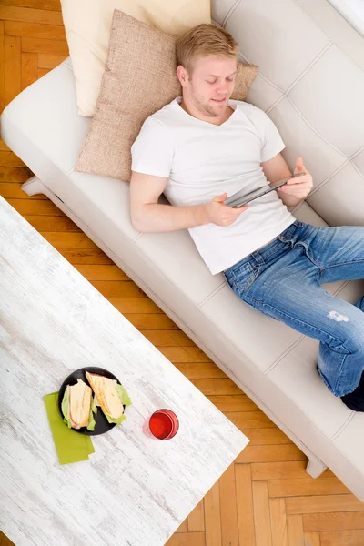 Young man using a tablet at home — Stock Photo, Image