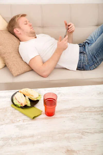 Ung man använder en tablett hemma — Stockfoto