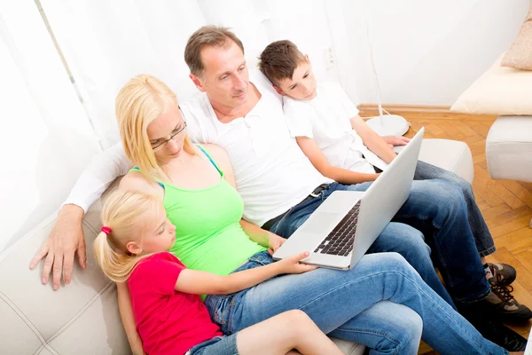 Familia feliz en el sofá — Foto de Stock