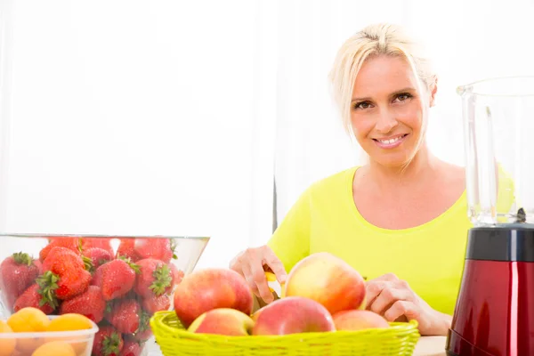 Mulher madura preparando um smoothie — Fotografia de Stock