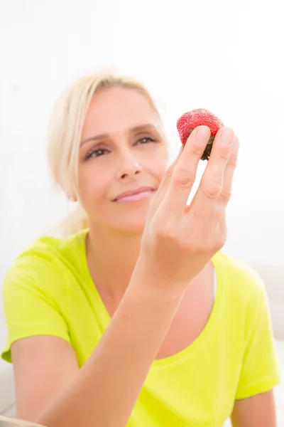 Mature woman eating strawberry – stockfoto