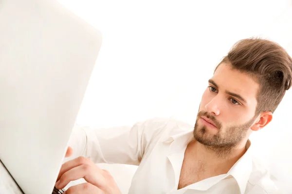 Молодой самец дома с ноутбуком — стоковое фото