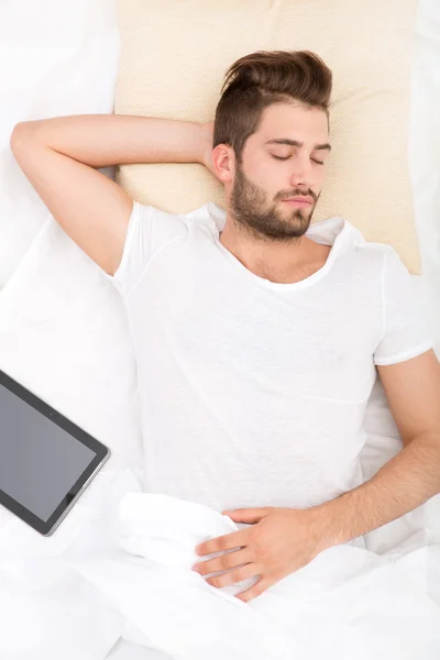 Portrait of a young man from above sleeping in a white bed — Stock Photo, Image