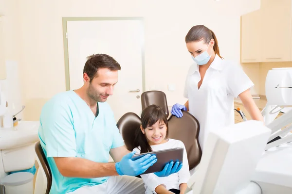 Dentista com uma menina e um Tablet Pc — Fotografia de Stock