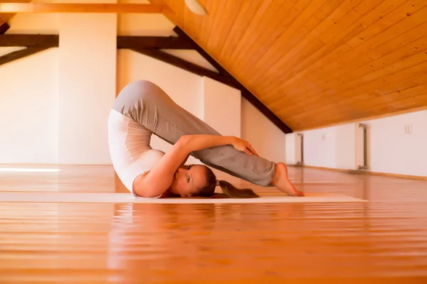 Kvinna som utövar yoga i en studio — Stockfoto