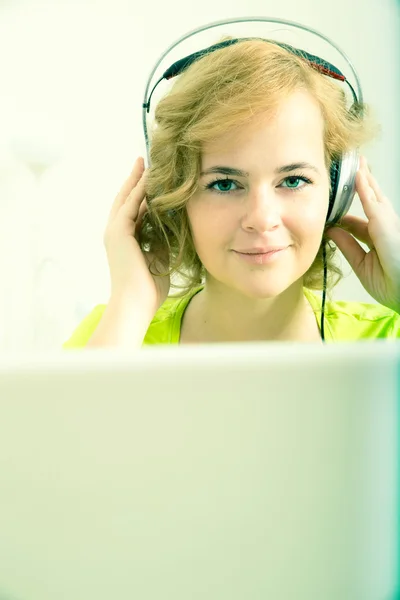 Молодая женщина plus size слушает аудио перед ноутбуком — стоковое фото