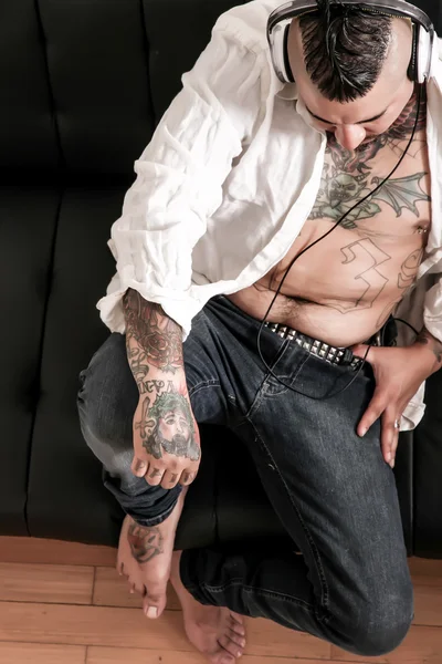 Homme tatoué sur le canapé — Photo