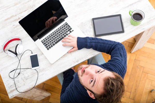 Egy fiatal férfi, online otthoni irodában dolgozik — Stock Fotó