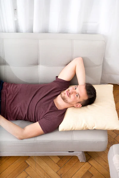 Jonge man ontspannen op de sofa — Stockfoto