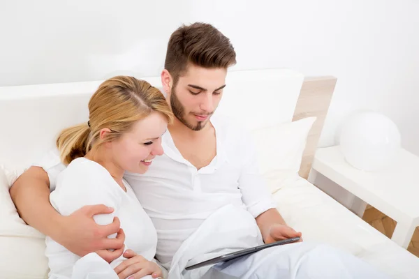 Young couple with a Tablet PC in Bed — Stock Photo, Image