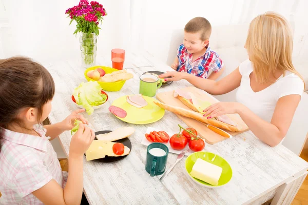 Gelukkig gezin ontbijten thuis — Stockfoto