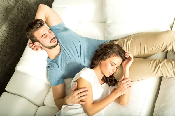 Jeune couple câlin sur le canapé à la maison — Photo