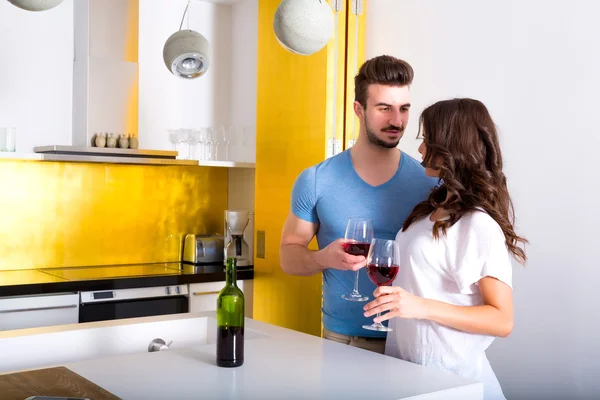 Pareja joven bebiendo vino en la cocina —  Fotos de Stock