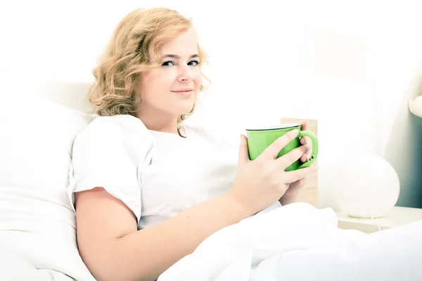 Young woman drinking coffee in Bed — Stock Photo, Image