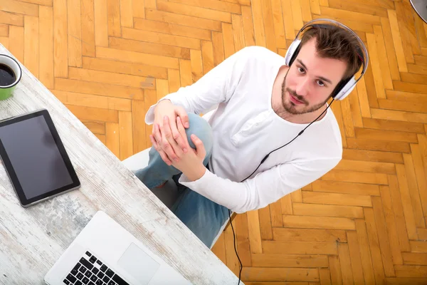 Ung man lyssnar musik på hans Laptop — Stockfoto