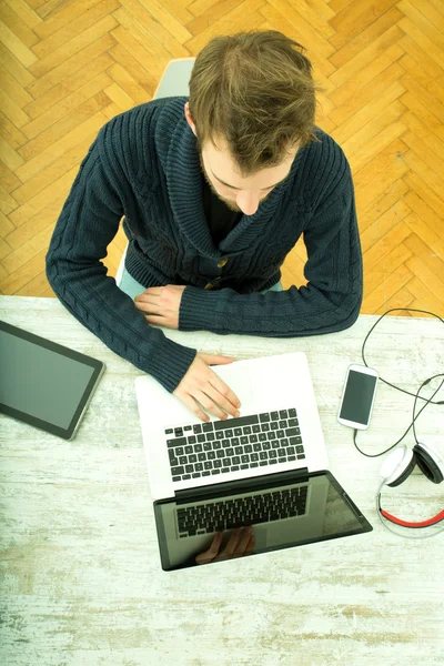 Ung man använder sin laptop dator hemma — Stockfoto