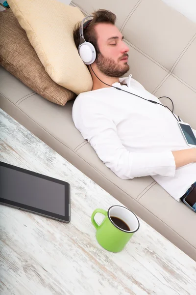 En el sofá con los auriculares — Foto de Stock