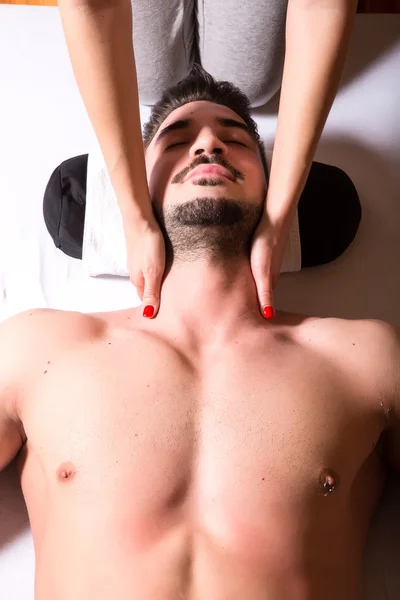 Молодой массажист делает массаж шеи — стоковое фото