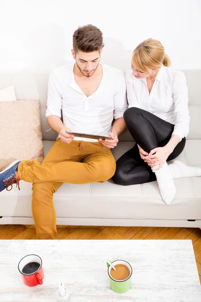 Young couple talking on the sofa — Stock Photo, Image