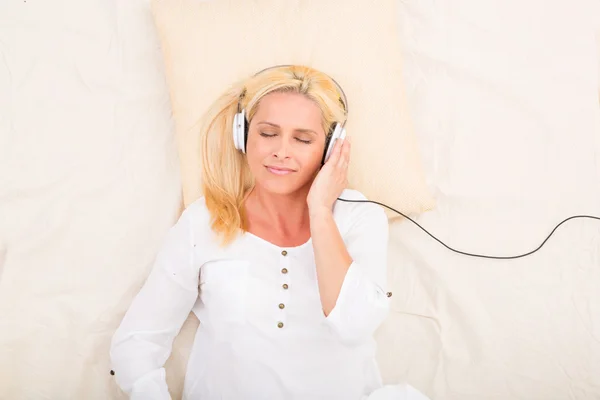 Mujer con auriculares y tablet en la cama —  Fotos de Stock