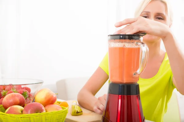 Mature woman blending a smoothie — Stock Photo, Image