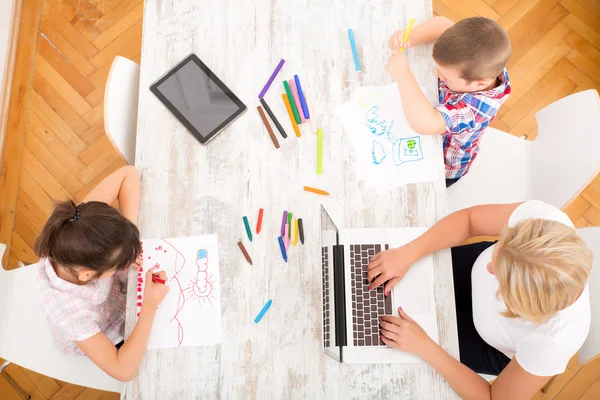 Mor och barn med en bärbar dator hemma — Stockfoto