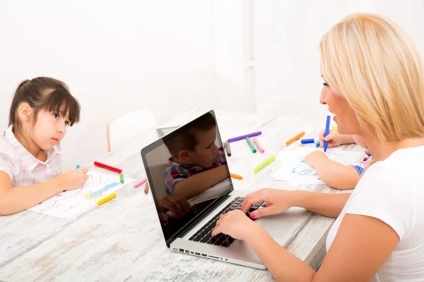 Matka i dzieci z laptopa w domu — Zdjęcie stockowe