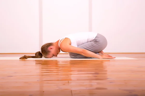 Mulher praticando Yoga em um estúdio — Fotografia de Stock