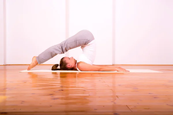 Vrouw die yoga beoefent in een studio — Stockfoto