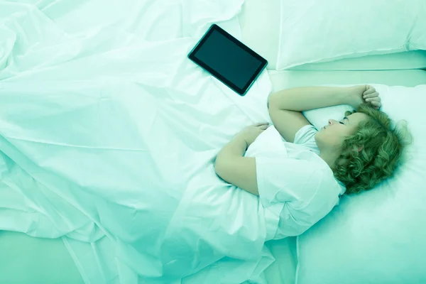 Junge Frau schläft mit Tablet-PC im Bett — Stockfoto