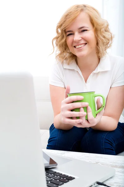 Jeune femme sur le canapé avec Gadgets — Photo