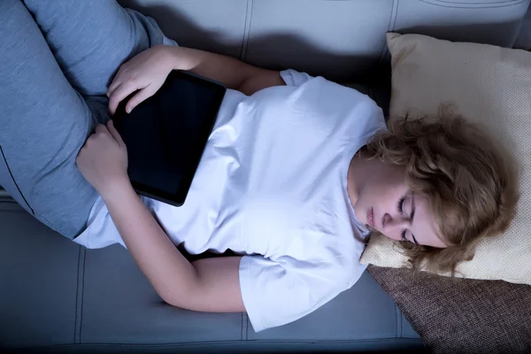 Femme dormant la nuit avec une tablette PC sur le canapé — Photo