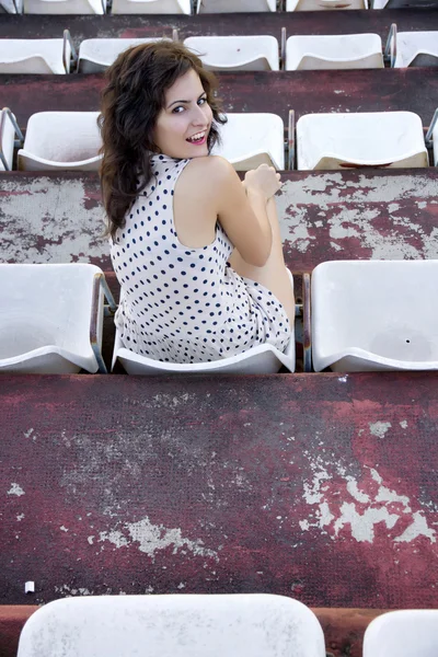 Retro girl sitting in stadium — Stock Photo, Image