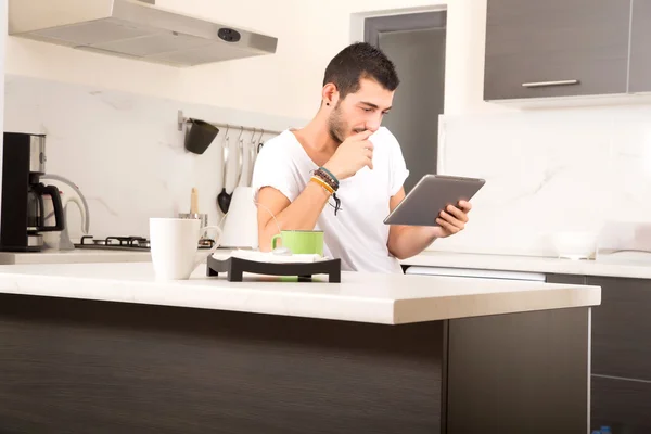 Joven con la tableta en la cocina — Foto de Stock