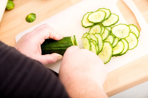 Woman cutting cucumber — Stock Photo, Image